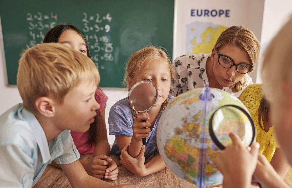 Institutrice avec des élèves dans un établissement scolaire