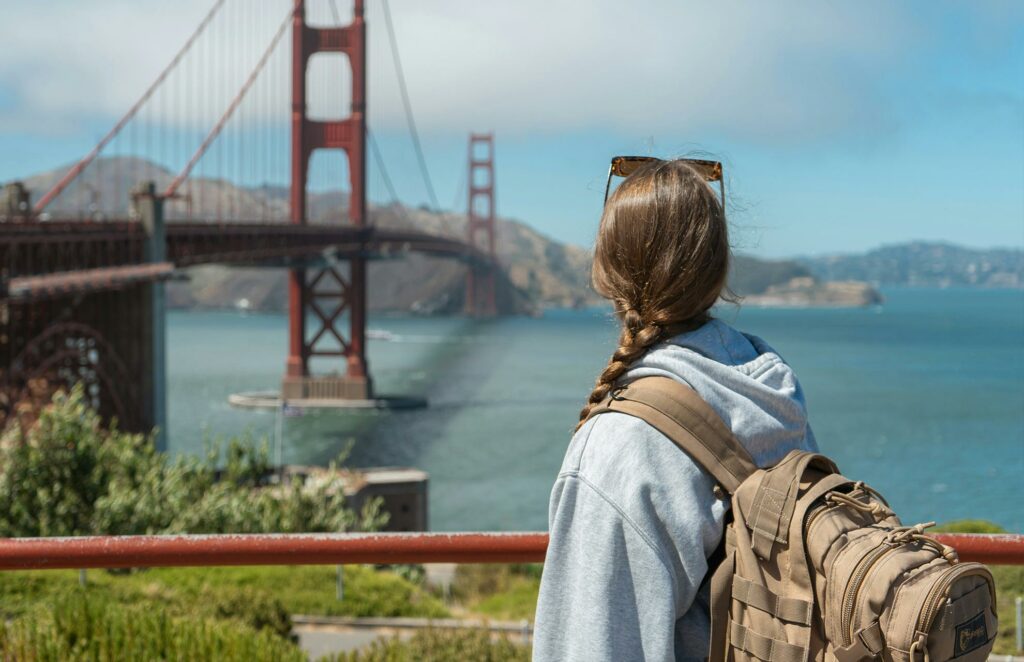 une jeune femme de dos devant le pont de San Francisco